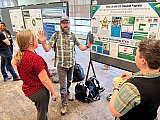 Earth Lab and ESIIL Education Director Nathan Quarderer holds forth next to his poster at Rendezvous 2024 - Rendezvous 2024