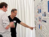 NOAA CSL Research Physicist Charles "Chuck" Brock points out something during the poster session at Rendezvous 2024 - Rendezvous 2024